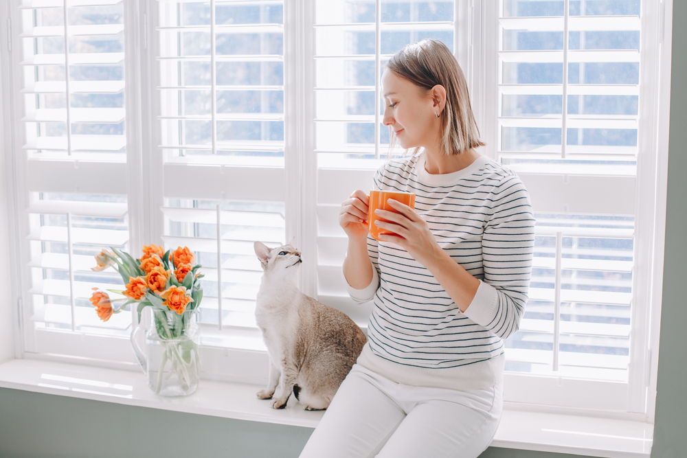 Beautiful,Happy,Middle,Age,Woman,Sitting,On,Windowsill,At,Home